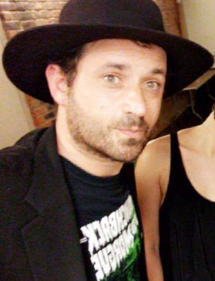 Portrait of Josh Melerman, white man wearing a black hat. 